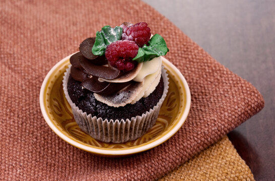 Chocolate vanilla cupcake with raspberries still life stock images. Delicious creamy cupcake with berries on the table stock photo. Fresh cupcake with berries close-up stock images