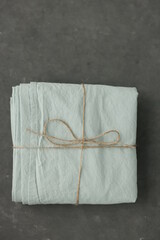 photo of natural and ecological washed cotton fabric sample in mint colour on dark background rewound with sack thread