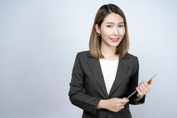 Beautiful Asian businesswoman in a black suit, isolated on a white background.