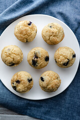 A plate of freshly baked gluten-free dairy-free blueberry muffins dusted with sugar.