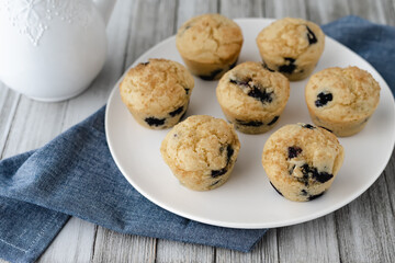 Flat lay of a plate of freshly baked gluten-free dairy-free blueberry muffins.