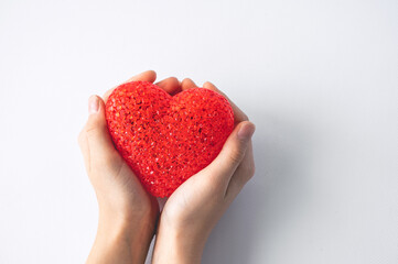 Fototapeta premium The girl is holding a red heart, isolated on a white background