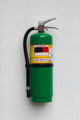 Naklejka premium Dry chemical powder fire extinguishers A green bucket on a white wall