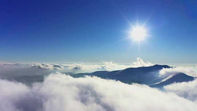 A beautiful and gentle view of an extraordinary and fluffy cloud valley and a bright orange sunset, aerial UHD 4K video