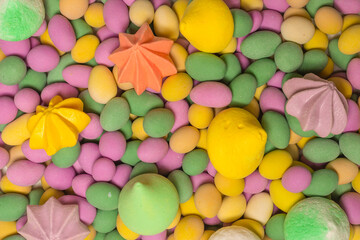 Fototapeta na wymiar Colorful meringues and glazed peanuts isolated on a white background.