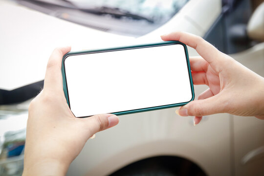 A woman holds a smartphone to take pictures of the area of ​​a car crash in the accident. To collect as evidence of car insurance claim. White screen