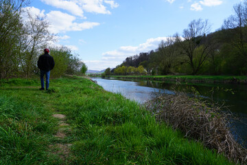 ein radfahrer macht pause und l&auml;uft an dem Fluss Leine entlang - a cyclist takes a break and walks along the river Leine