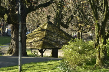 Fototapeta na wymiar L'abris hexagonal en rocaille sous les marronniers majestueux du parc Huart Hamoir à Schaerbeek