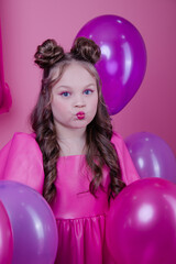 pretty brunette girl teenager with blue eyes and pink make up among balloons on pink background. party, birthday, holiday