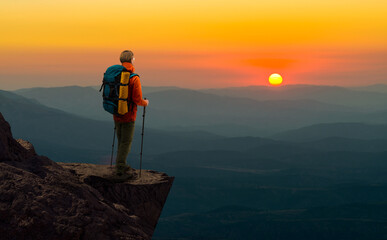 tourist - backpacker in touristic equipment stand on mountain peak