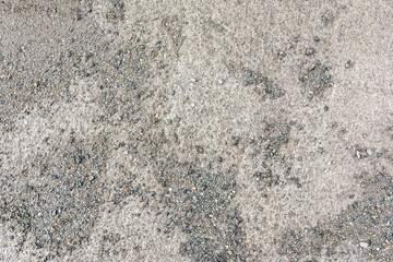 the muddy concrete road is covered with fine gravel chips as a natural backdrop