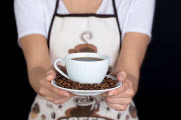 Ceramic cup and coffee beans on a black background.
