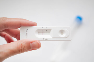 Hand holding rapid test kit for detecting coronavirus antigen. Single mark on C area, which mean negative result, Virus was not detected. Selective focus