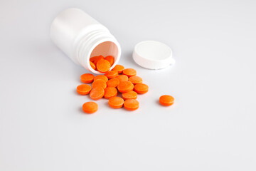 A handful of tablets vitamin C tablets on white background. Healthy lifestyle concept. Copy space. Close-up.