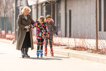 grandmother teaches granddaughter to roller skate