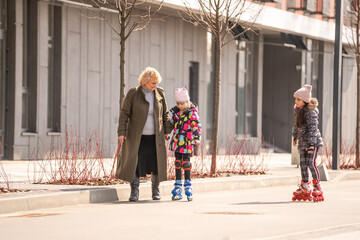 grandma teaches two granddaughters to roller skate