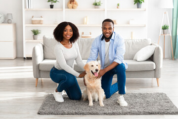 Young black couple hugging with dog posing at home