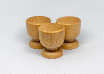 Three empty rustic wooden cups on a white background, photographed from the front