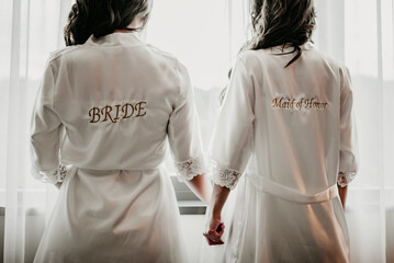 wedding details for bride and maid of honor pink and white bathrobes preparations	