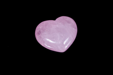 Macro mineral stone Heart pink quartz on a black background