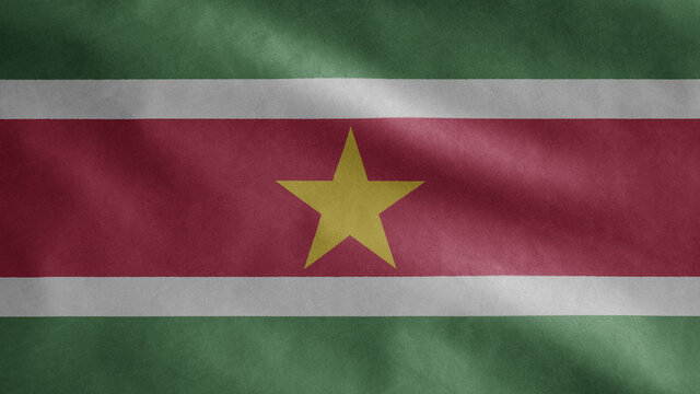 Surinamese flag waving in the wind. Close up Suriname banner blowing soft silk.