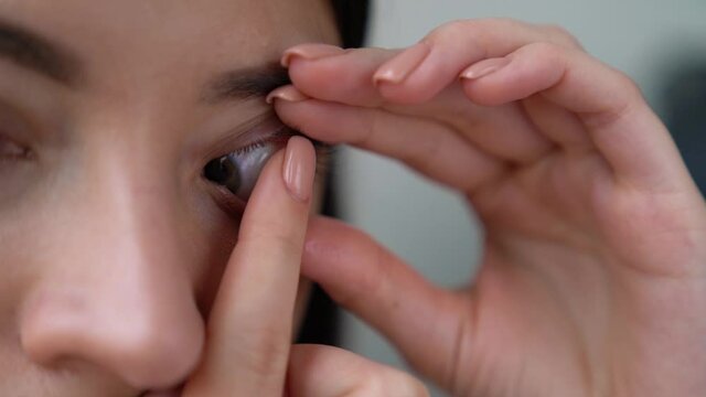 Closeup female hand is holding contact lenses. Woman is preparing to put in eye soft silicone optical lenses. Vision correction of myopia, hyperopia, astigmatism concept. Ophthalmic diseases.