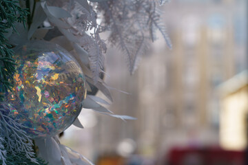 Details of the New Year decoration  of Moscow. White glass ball. Closeup. Street of the capital of the Russian Federation. Architecture as background. Concept of still life