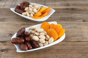 Tray of dried fruits on a wooden base. Copy space.