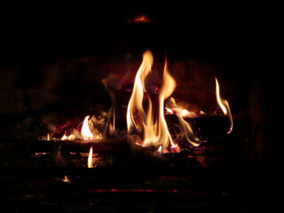 Fire burning in fireplace, close up of orange flames eating firewood
