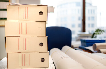 rolls of printed layouts lies on a folder on the table against the background of paper folders