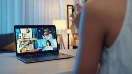 Young Asia female drinking beer having fun happy moment night party event online celebration via video call in living room at house at night. Social distancing, quarantine for coronavirus prevention.