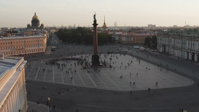  Aerial footage of Palace Square and Alexander Column at sunset, a gold dome of St. Isaac's Cathedral, the Winter Palace, the Hermitage, little people walks