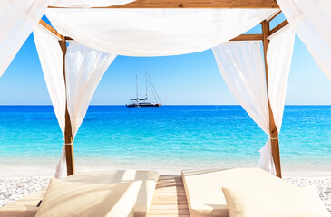 Fototapeta na wymiar Nice tropical white sandy beach with bed in Punta Cana, Dominican Republic.