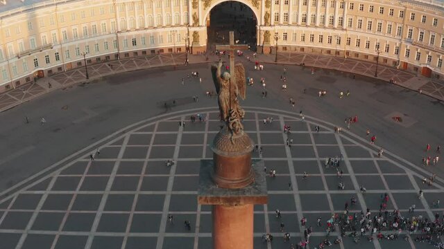 Aerial footage of Palace Square through a triumphal chariot, rear view, winged Nick, a symbol of military glory, over arch of the General Staff Building, the Aleksandr column, the Winter Palace