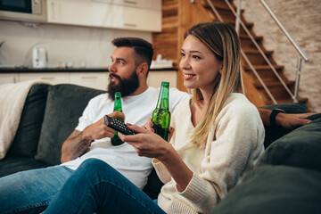 Young happy couple drinking beer at home