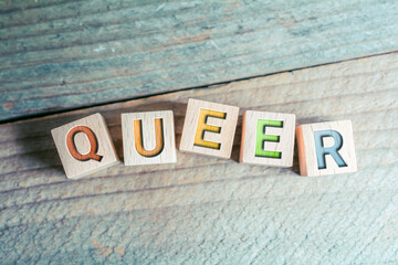 Queer In Colored Letters Written On Wooden Blocks On A Board