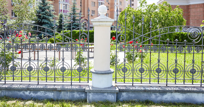 Wrought iron fence. Image of a Beautiful decorative cast iron wrought fence with artistic forging and stone columns