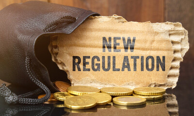 On the table is a bag of money from which sticks out cardboard with the inscription - NEW REGULATION