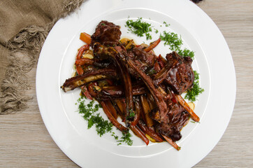 grilled lamb ribs with vegetables on a white plate