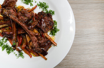grilled lamb ribs with vegetables on a white plate