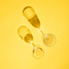 two glass of wine on yellow sunny summer background. tropical summer party. creative decoration idea
