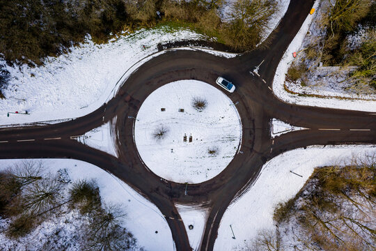 Top Down Aerial View Of A Traffic Roundabout Covered In Fresh Snow