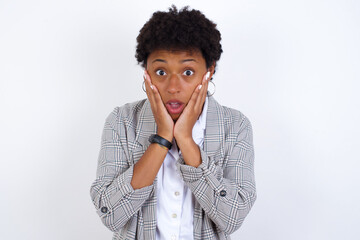 Fototapeta na wymiar Scared terrified African American businesswoman with curly bushy hair wears formal clothes over white background shocked with prices at shop, People and human emotions concept