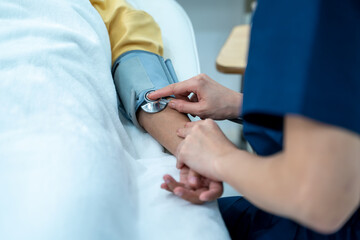 Female doctor examining female patient with his stethoscope at the hospital,Health insurance and medical care contract.