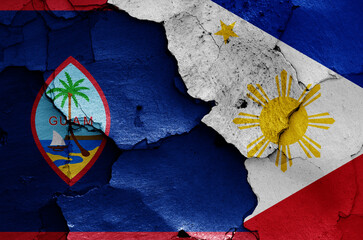 flags of Guam and Philippines painted on cracked wall