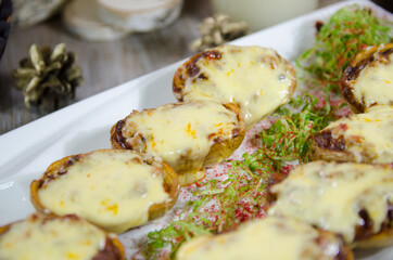 baked potatoes stuffed with meat and melted cheese on the Christmas table