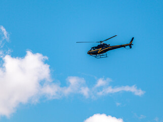 Fototapeta na wymiar Helicóptero preto no céu azul