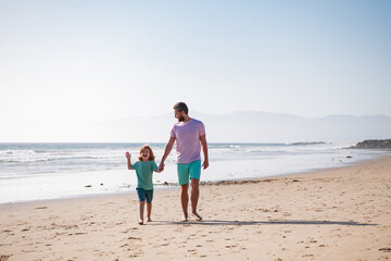 Father and son walking on summer beach. Dad and child playing outdoor.