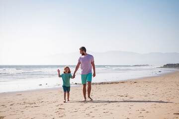 Father and son walking on summer beach. Dad and child playing outdoor.