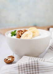 Healthy breakfast of yogurt with banana, walnuts and cinnamon